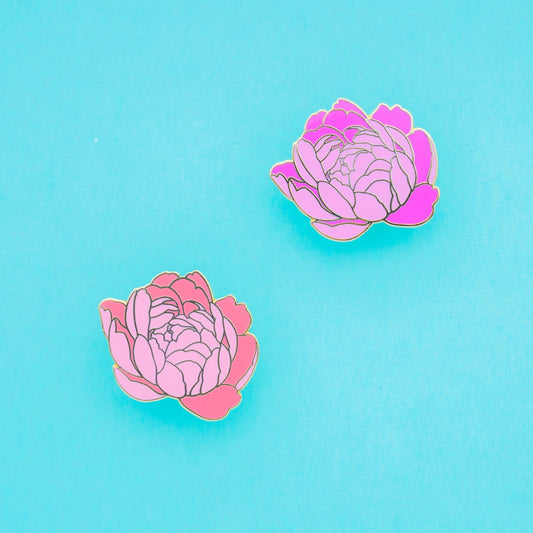 A pair of matching fuschia and coral peony enamel pins with beautiful gold details