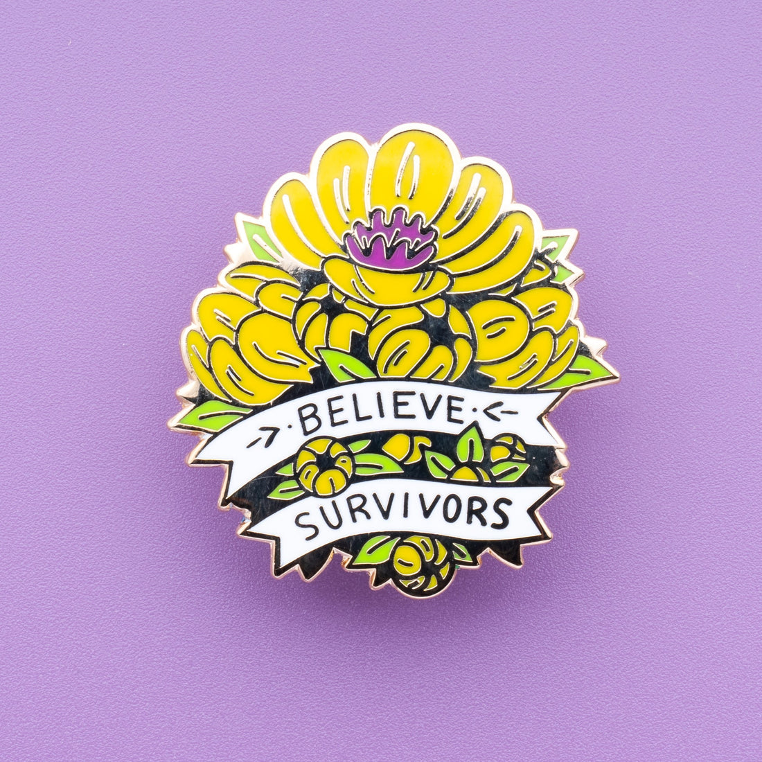 A vibrant yellow Potentilla enamel pin featuring a magenta center and fresh green leaves, inspired by vintage botanical illustrations. The design includes a white motto riband banner with handwritten text that reads "Believe Survivors."