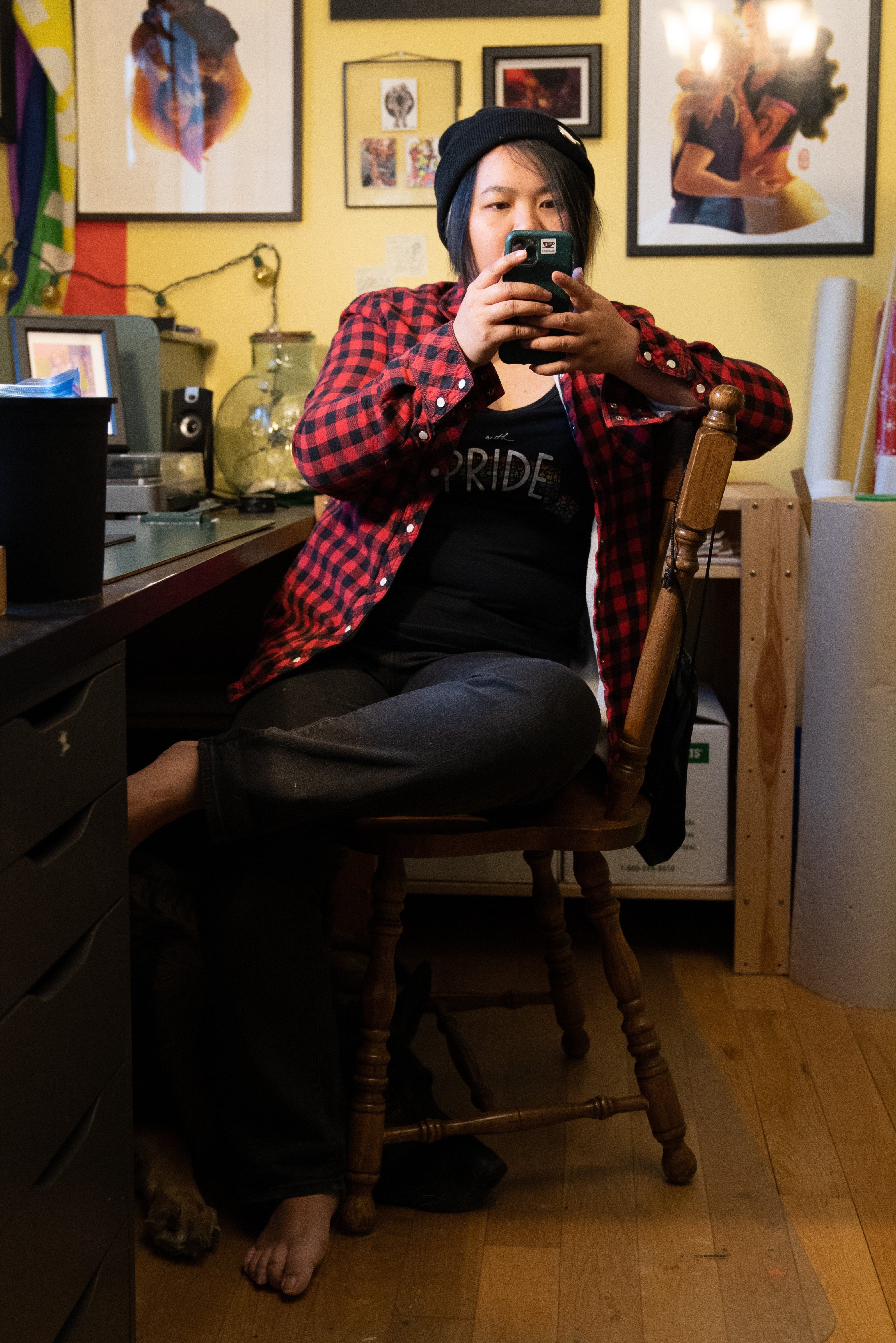 Person sitting on a chair in a room with colorful walls and various items.