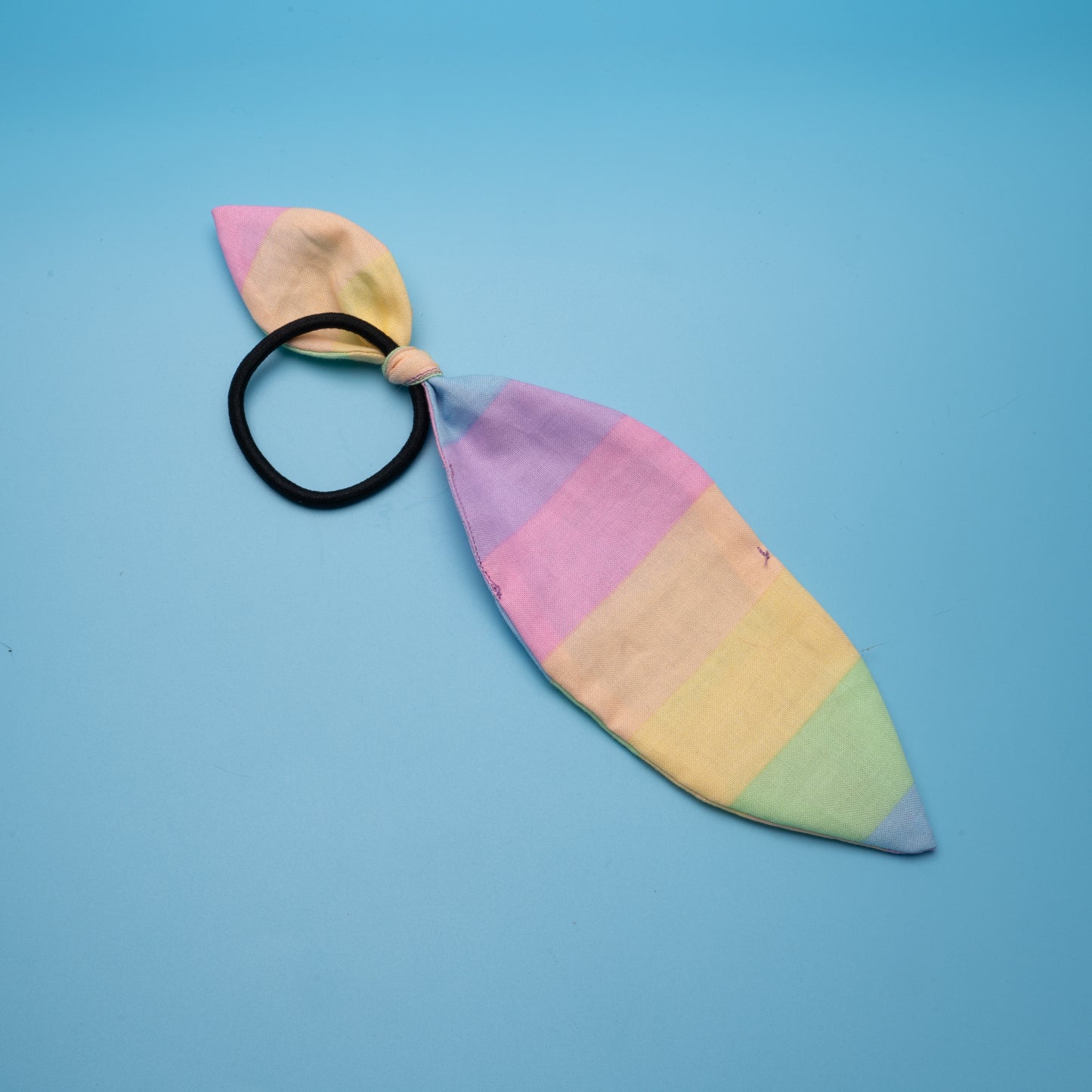 handmade hair bow tie with pastel rainbow fabric and asymmetrical ears