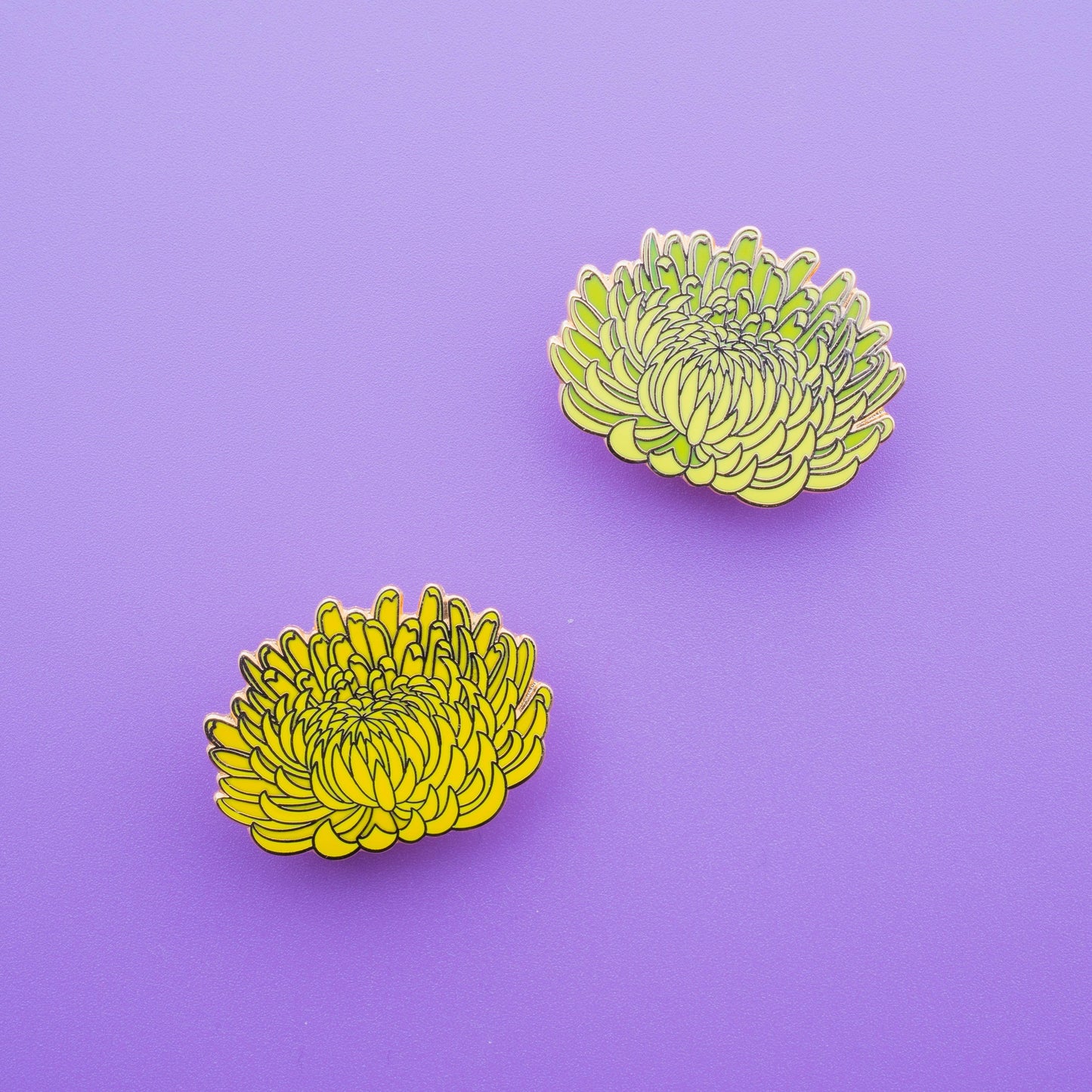 2 beautifully detailed crysanthemum enamel pins, one yellow and one green yellow