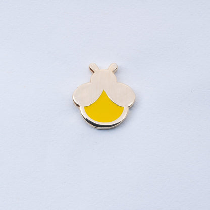 gold plated mini firefly enamel pin with yellow body that glows in the dark
