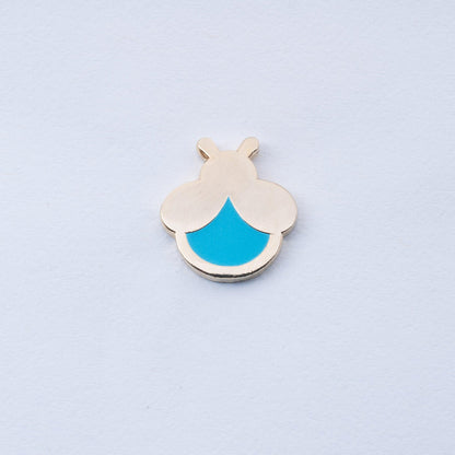 gold plated mini firefly enamel pin with cyan body that glows in the dark