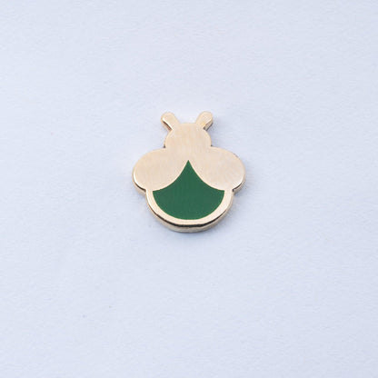 gold plated mini firefly enamel pin with dark green body that glows in the dark