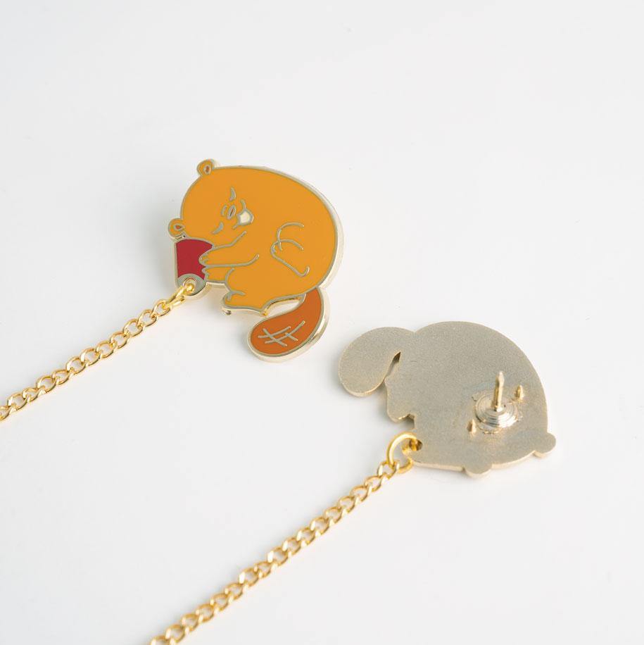 cute curled beaver holding red cup to its ear pin with chain attached